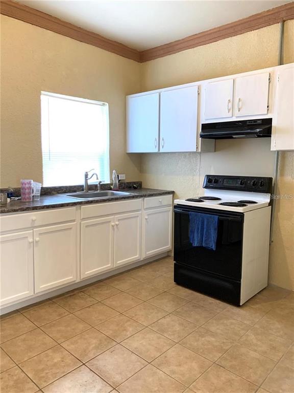 100 John Street Frostproof, FL 33843 - Photo 12 of 15 a kitchen with stainless steel appliances granite countertop a stove a sink and a microwave