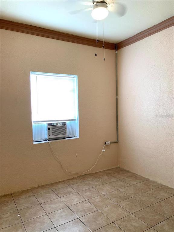 100 John Street Frostproof, FL 33843 - Photo 7 of 15 an empty room with a chandelier fan and windows