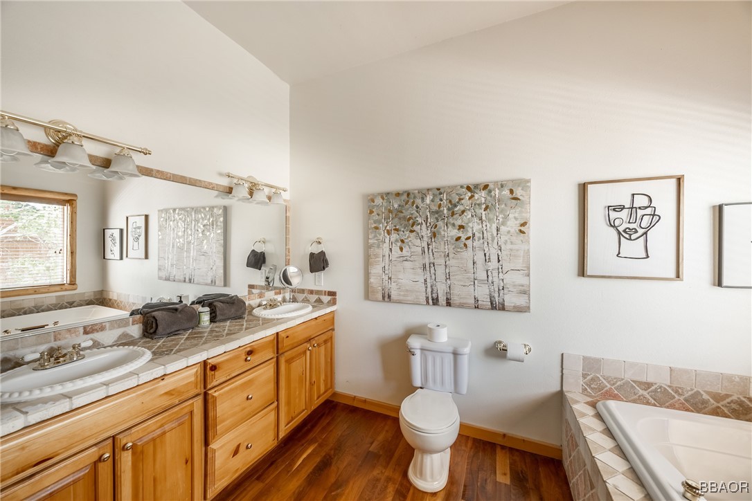 42577 Bear Loop Big Bear City, CA 92314 - Photo 24 of 38 a bathroom with a granite countertop sink mirror vanity bathtub and toilet