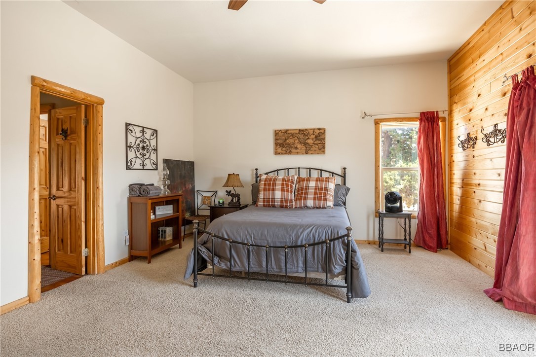 42577 Bear Loop Big Bear City, CA 92314 - Photo 31 of 38 a bedroom with a bed and a chandelier