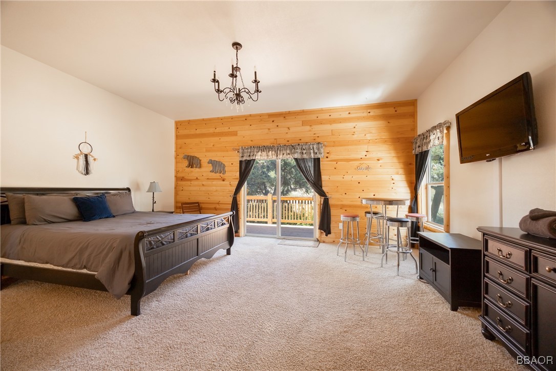 42577 Bear Loop Big Bear City, CA 92314 - Photo 33 of 38 a spacious bedroom with a bed and a flat screen tv
