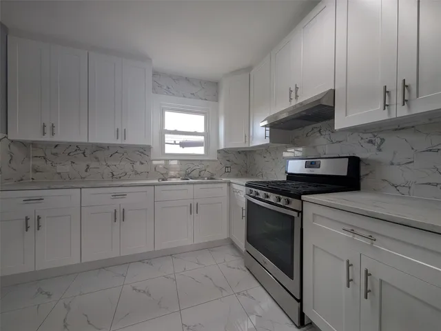 a kitchen with cabinets appliances and a window