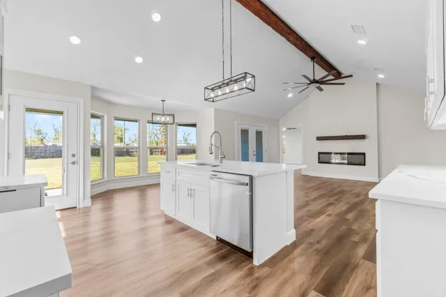 a open kitchen with white cabinets and stainless steel appliances