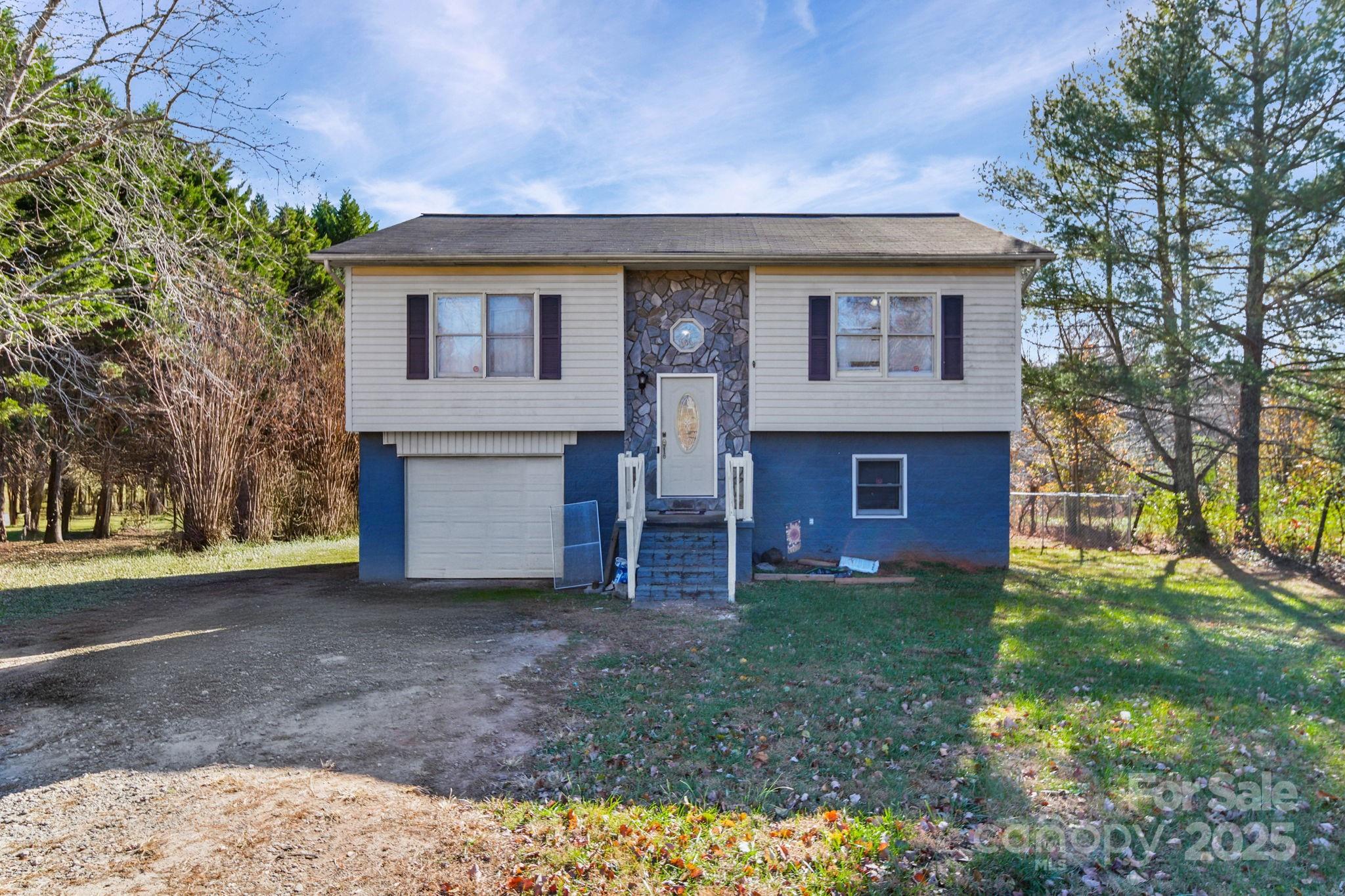a front view of house with yard and trees in the background