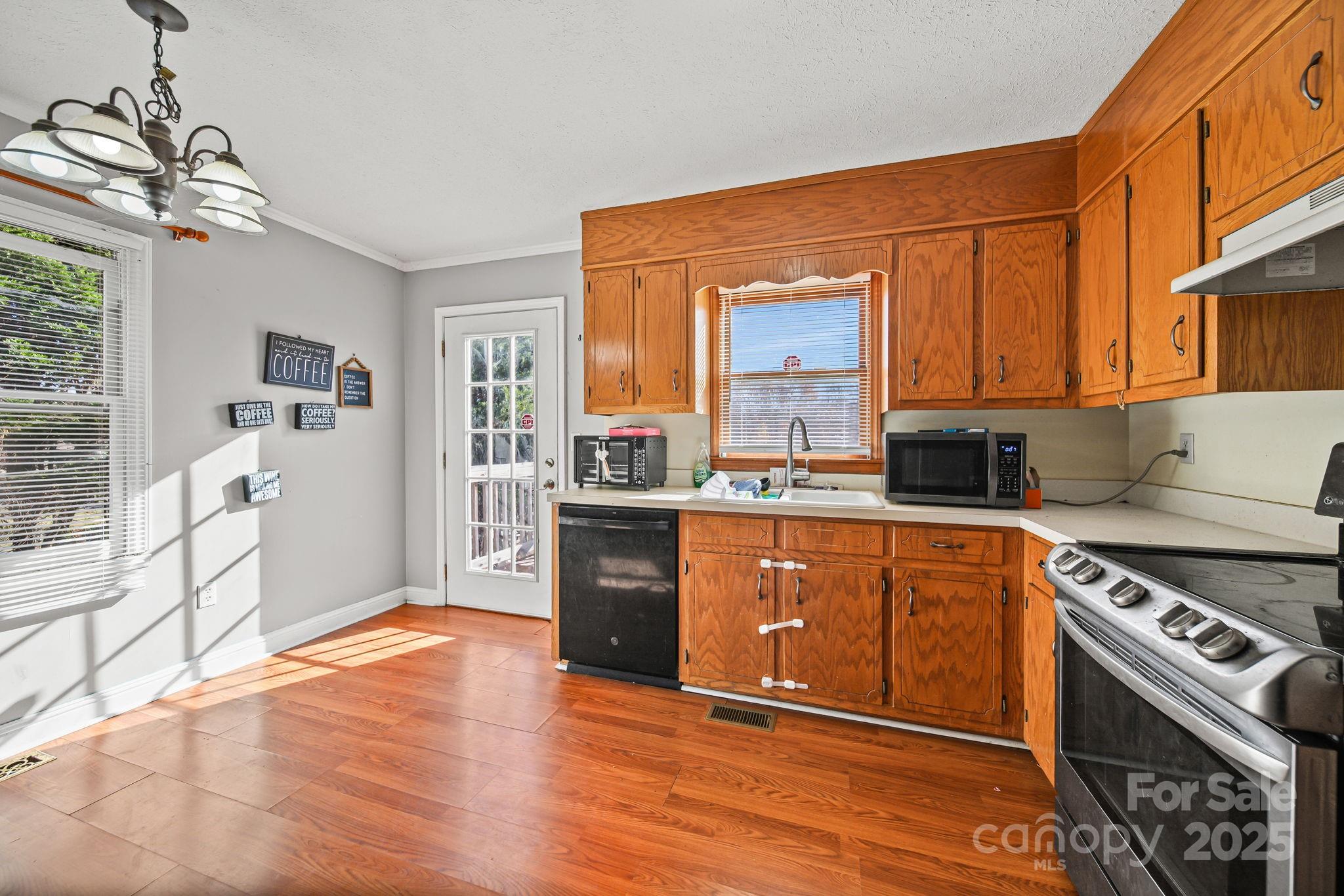 3405 Clarks Chapel Road Lenoir, NC 28645 - Photo 13 of 25 a kitchen with stainless steel appliances granite countertop a stove a sink dishwasher and a refrigerator with wooden floor