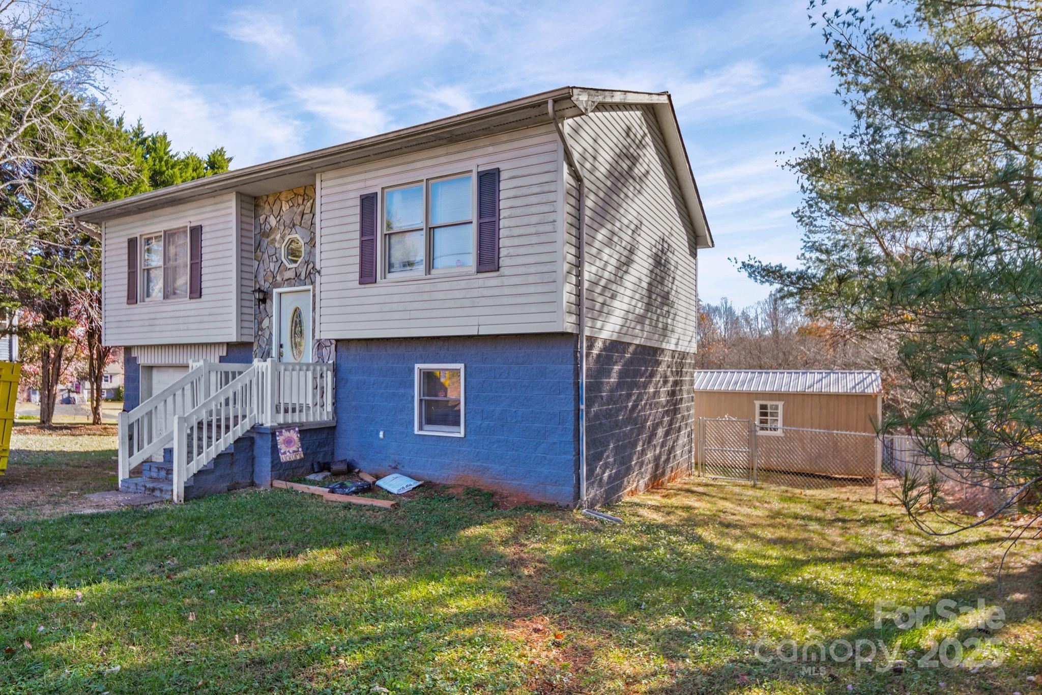 3405 Clarks Chapel Road Lenoir, NC 28645 - Photo 2 of 25 a backyard of a house with plants and wooden fence