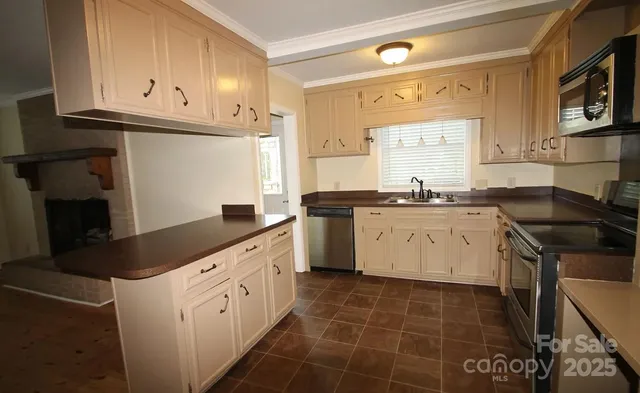 a kitchen with a sink dishwasher a stove top oven a washer and dryer with wooden cabinets