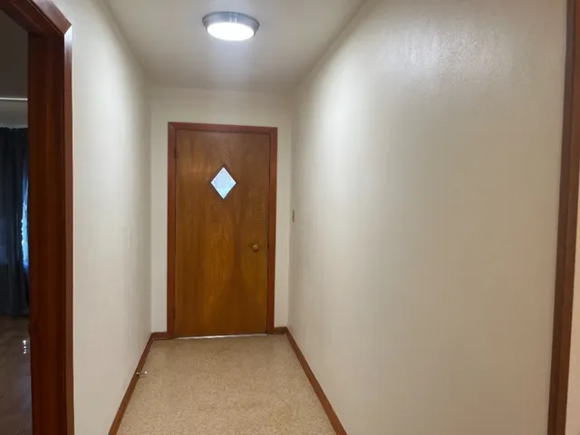 a view of an empty room with closet and a window