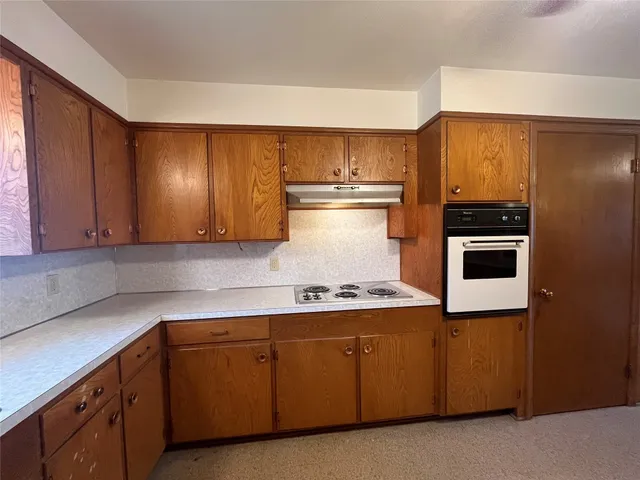 a kitchen with cabinets and white stainless steel appliances