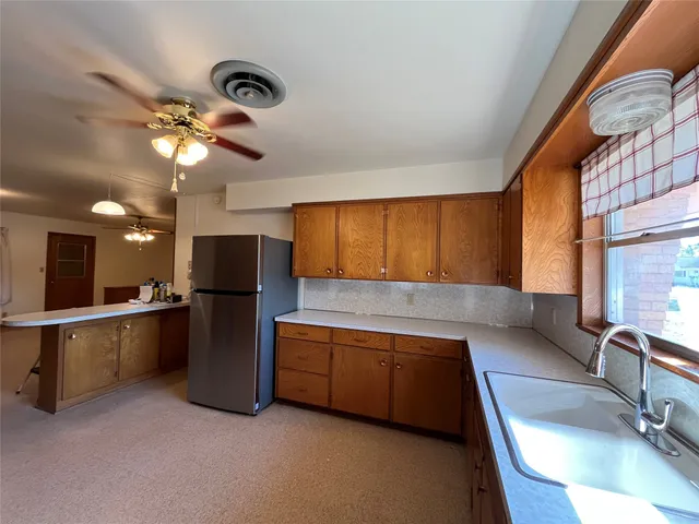 a kitchen with stainless steel appliances granite countertop a sink a stove and a refrigerator