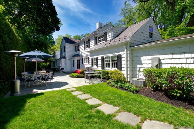 a view of a table and chairs under an umbrella in patio with a yard