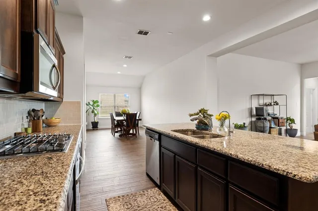 a kitchen with sink stove and cabinets
