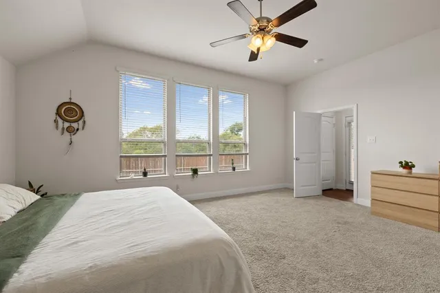 a spacious bedroom with a large bed and a chandelier