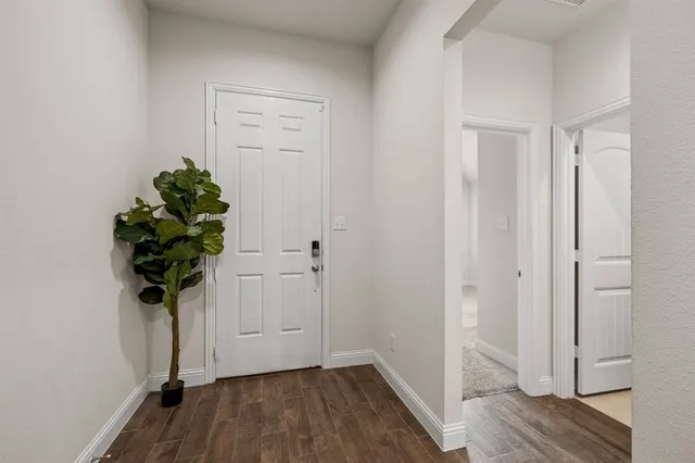 a view of a hallway with wooden floor and glass door