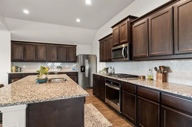 a kitchen with granite countertop a stove sink and cabinets