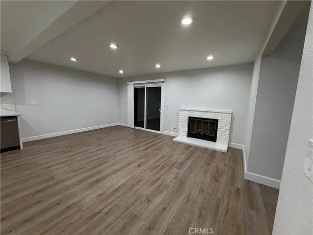 an empty room with wooden floor and fireplace