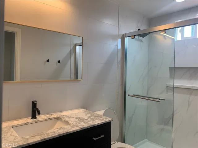 a bathroom with a granite countertop sink and mirror