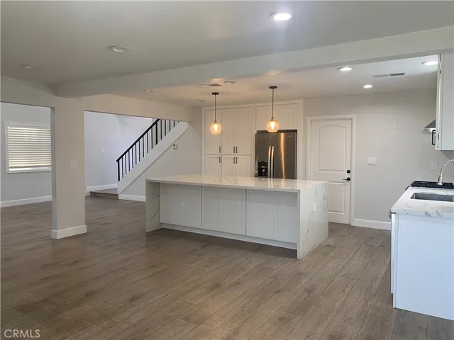 a view of a kitchen with furniture and wooden floor