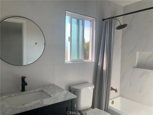 a bathroom with a toilet a sink and a mirror