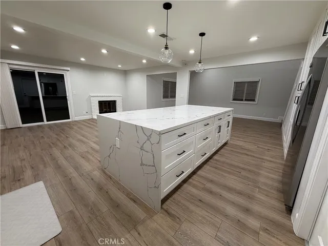 a spacious bathroom with a sink a large mirror and a wooden floor
