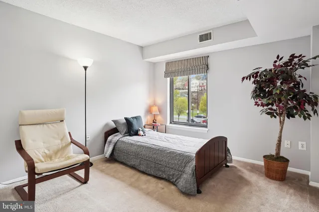 a bedroom with a bed and a potted plant