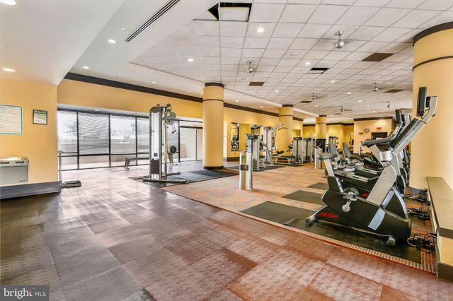 a room with stainless steel appliances kitchen island granite countertop a barbecue grill and couches with wooden floor