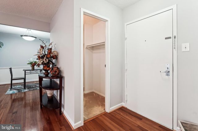 a view of a hallway with wooden floor and stairs