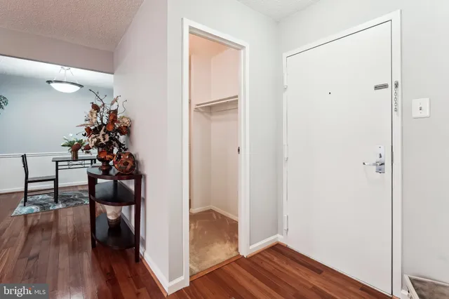 a view of a hallway with wooden floor and stairs