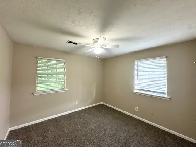 a view of a livingroom with a ceiling fan and window