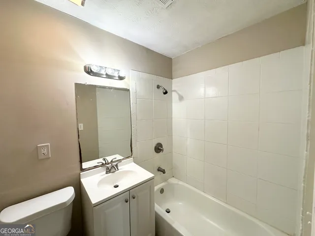 a bathroom with a sink mirror toilet and shower