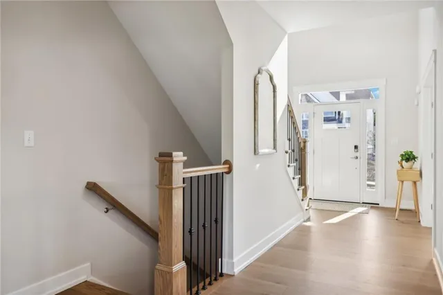 a view of a hallway with wooden floor and entryway