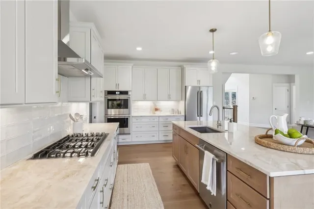 a large kitchen with kitchen island a large counter space a sink stainless steel appliances and cabinets