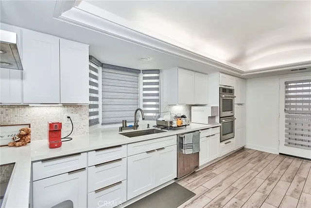 a kitchen with a sink dishwasher stove and cabinets