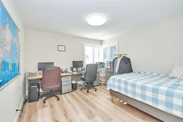 a bedroom with a bed a chair and a dresser next to a window