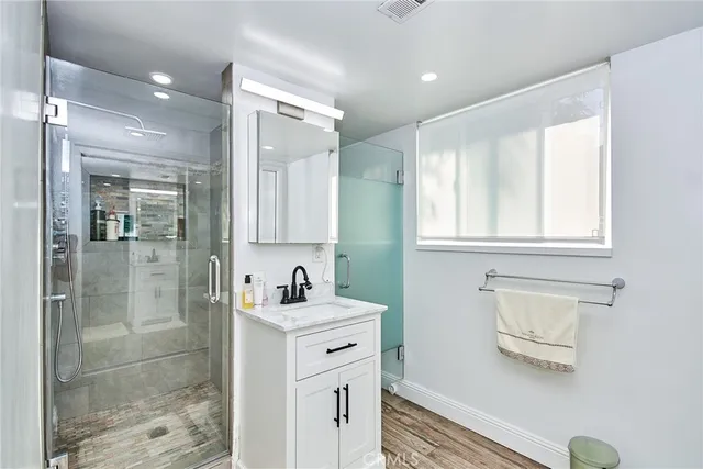a bathroom with a sink shower and a mirror