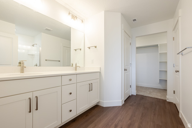 4816 Heartwood Road, Unit 423 Mapleton, UT 84664 - Photo 14 of 21 Full bathroom with double vanity, dark wood-style floors, a stall shower, and a walk in closet