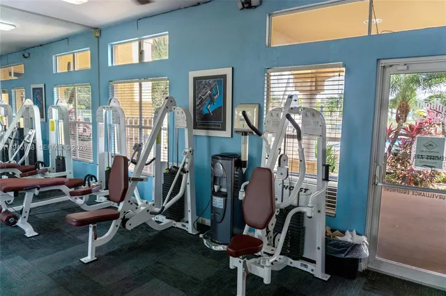 a room with gym equipment and large windows