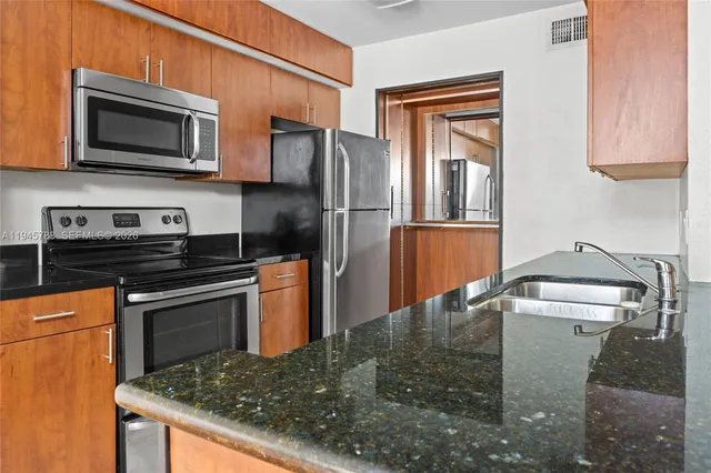 a kitchen with stainless steel appliances granite countertop a stove microwave and refrigerator