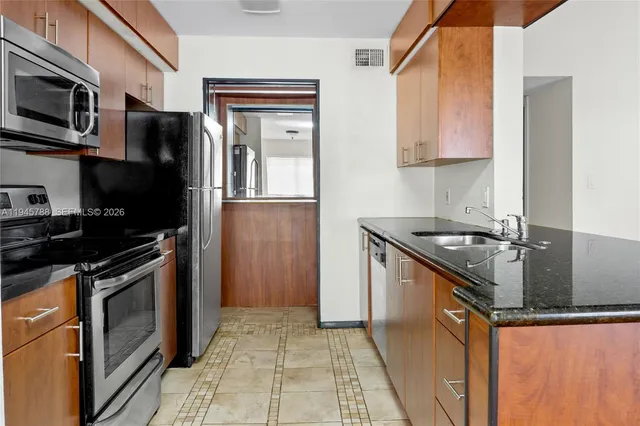 a kitchen with stainless steel appliances granite countertop a stove microwave and refrigerator