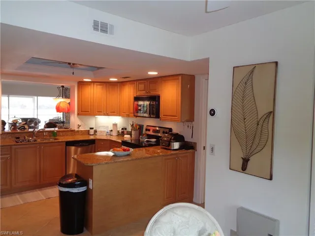 a kitchen with stainless steel appliances granite countertop a sink a stove and a refrigerator