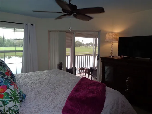 a bedroom with a bed and large window