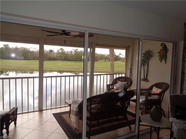 a living room with furniture and a floor to ceiling window