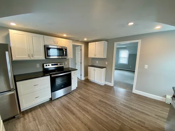 a kitchen with wooden floors and appliances