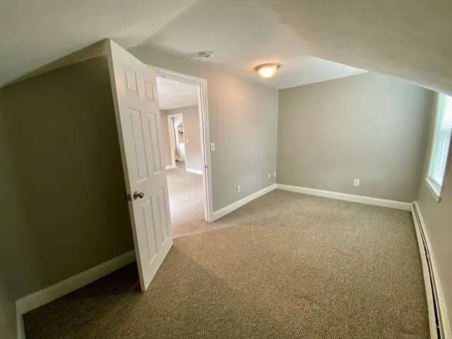a view of closet with wooden floor and small window