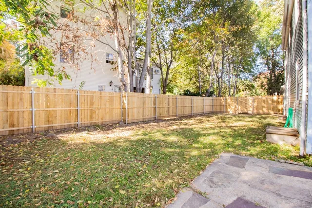 a view of a yard with wooden fence