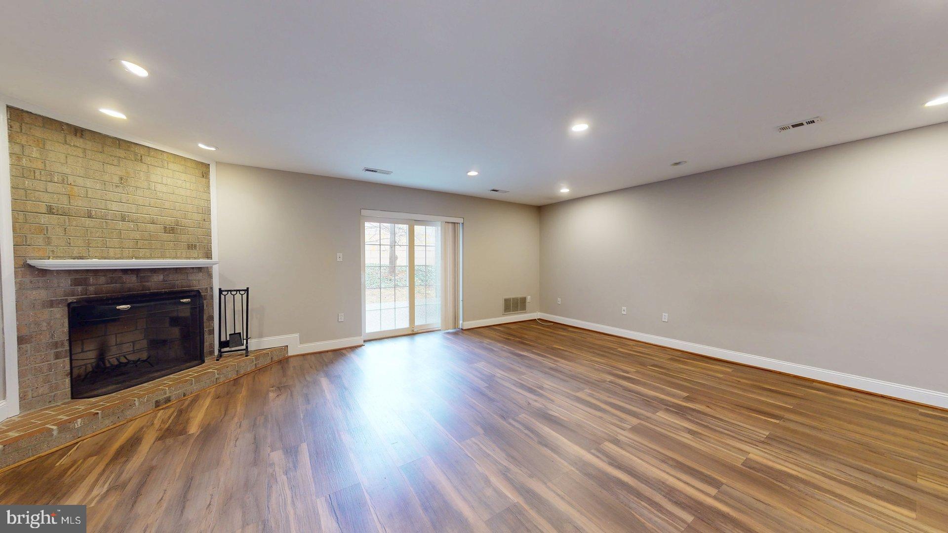 951 South Rolfe Street, Unit 1 Arlington, VA 22204 - Photo 3 of 18 an empty room with wooden floor fireplace and windows
