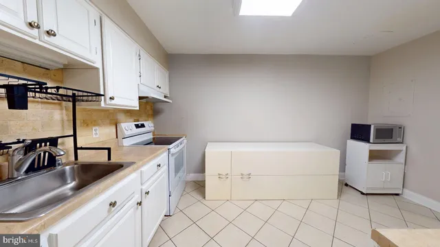 a kitchen with a sink and white cabinets