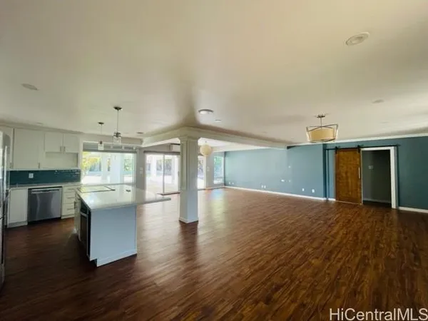 a view of a kitchen with furniture and wooden floor
