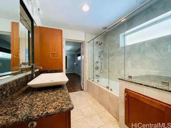 a bathroom with a granite countertop sink a toilet and shower