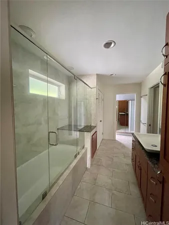 a spacious bathroom with a granite countertop sink a mirror and shower